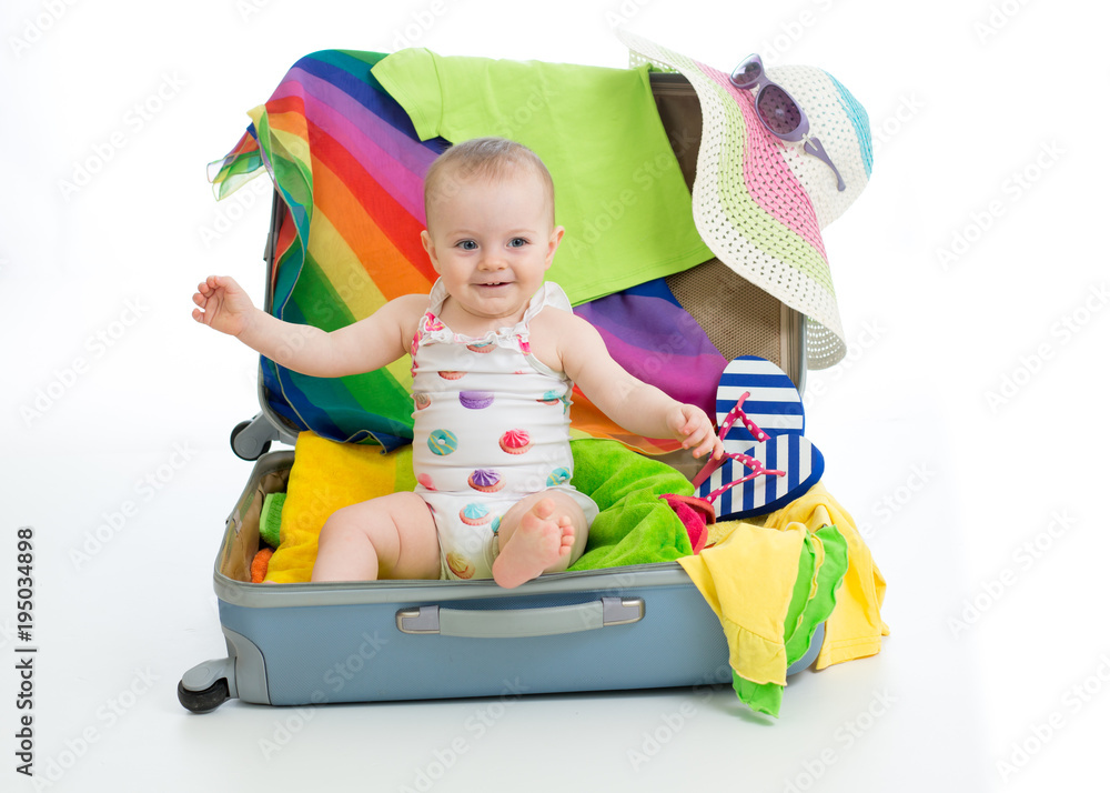 Baby girl sitting in trunk with things for vacation travel Baby girl sitting in trunk with things for vacation travel