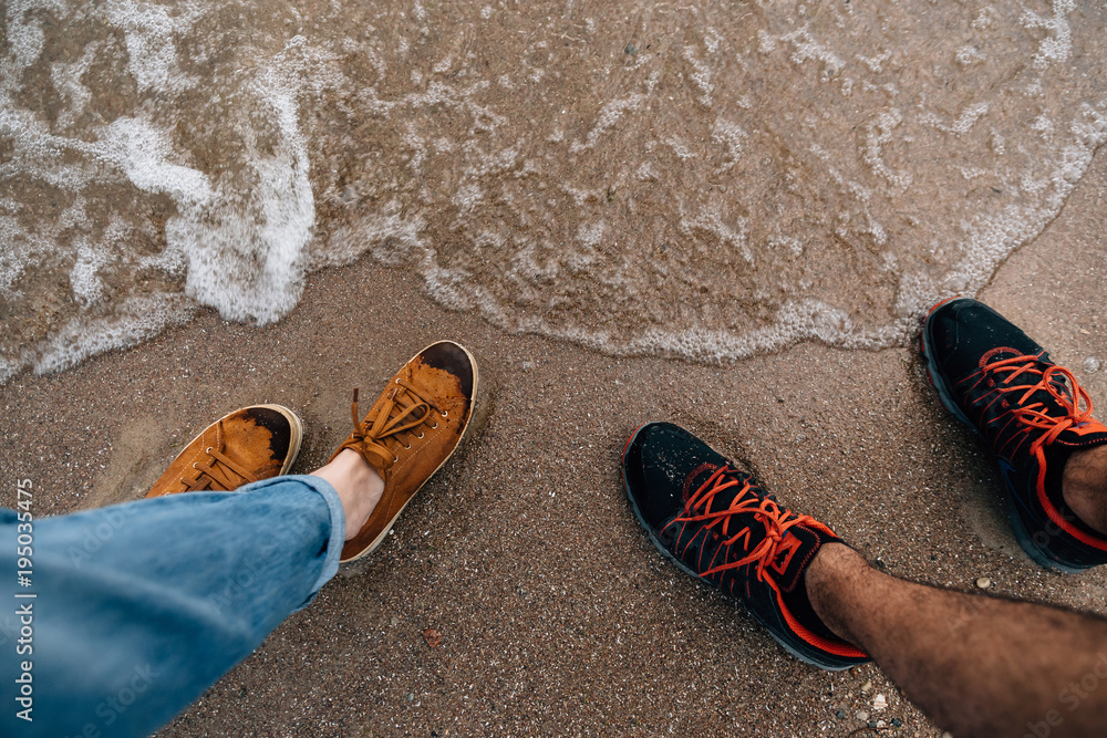 Naklejka premium feet on the sand near the water
