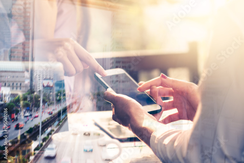 Business women are using a tablet and are using the phone.