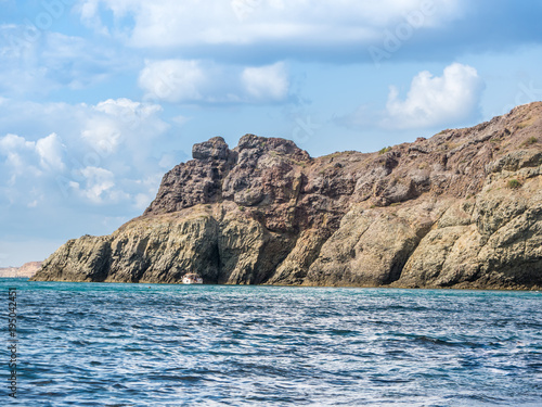 the rocky shore. high rocky cliff and boat at sea