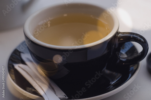 A cup of green tea on white table. Tea time at sunset.