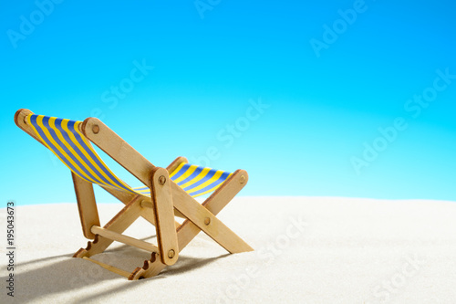 Sun lounger on the sandy beach and sky with copy space