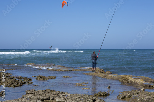 kitesurfers and fisherman