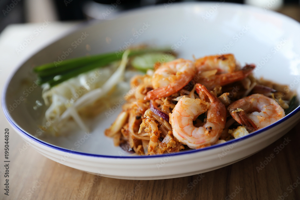 Pad thai with shrimp . Thai food on wood background