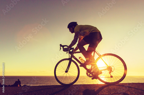 Road biking cyclist man training on bike professional cycling athlete riding racing bicycle in competition race on open road biking with high intensity on highway on workout for triathlon.