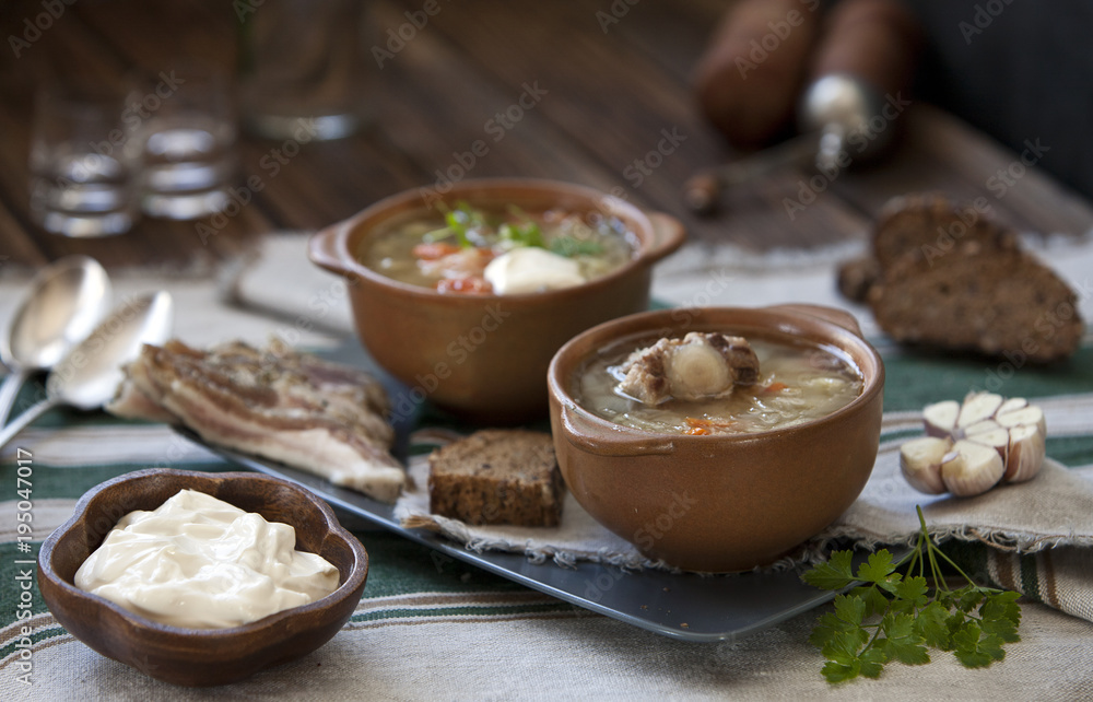 Close-up of tasty russian cabbage soup shchi in brown ceramic bowls on wooden table. Close-up, selective focus, shallow depth of field Close-up of tasty russian cabbage soup shchi in brown ceramic bowls on wooden table. Close-up, selective focus, shallow depth of field