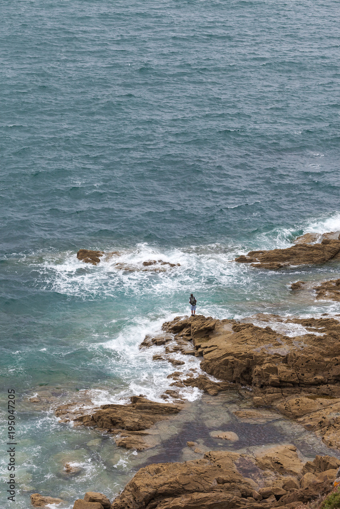 Lonely angler tries to catch a fish. Brittany coast. France Lonely angler tries to catch a fish. Brittany coast. France