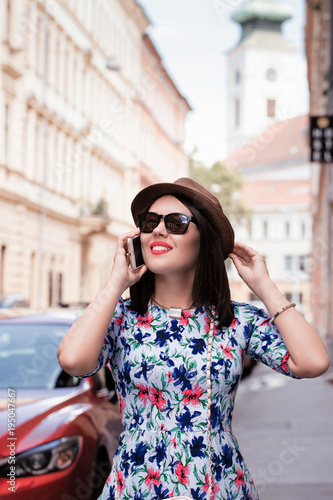 Pretty smiling young woman in a hat and sunglasses