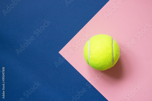 Tennis ball on blue and pink paper background. Concept sport. Copy space