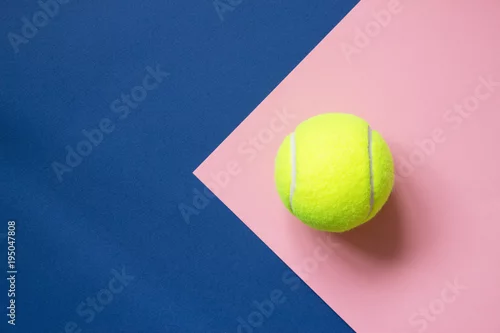 Obraz Tenisowa piłka na błękitnym i różowym papierowym tle. Sport koncepcyjny. Skopiuj miejsce