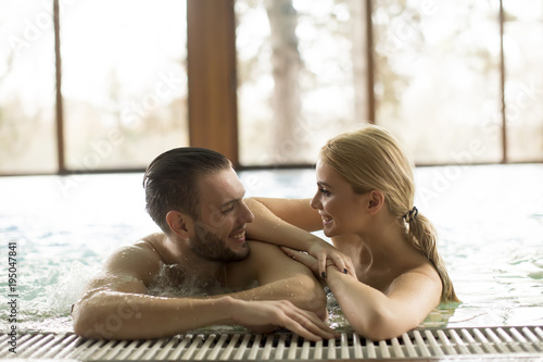 Loving couple relaxing at the spa in the pool