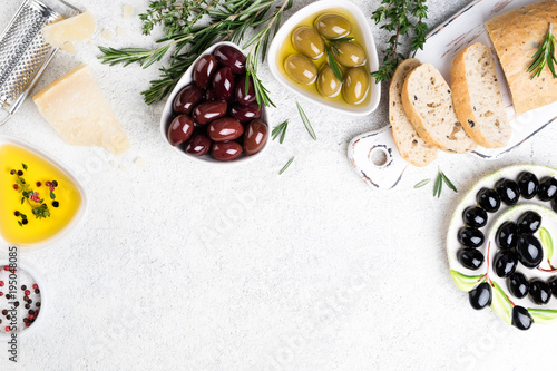Mediterranean snacks. Ciabatta bread, olives, cheese, oil, herbs and spices on white background. Copy space, top view