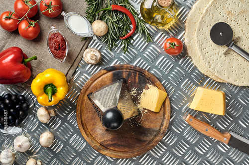 Cheese, different vegetables on metal table. Ingredients for traditional italian pizza.