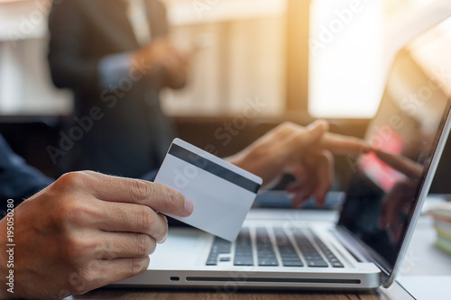 businessman holding credit card and using laptop computer. Online shopping concept