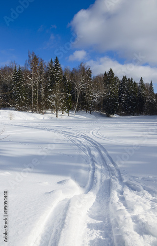 Ski track in snow.Frosty winter landscape.Sunny morning.Beautiful clouds in blue sky.Moscow region,Russia.