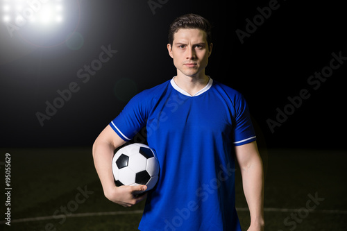 Footballer standing on football green