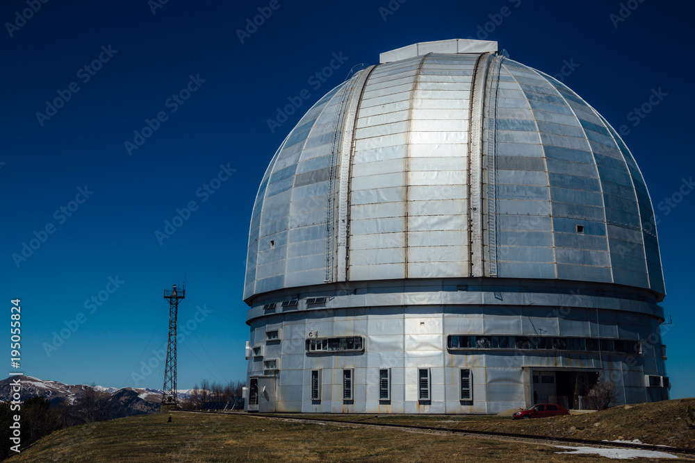 A special astrophysical observatory against the background blue sky and snowy peaks of the Caucasian mountains