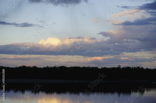 Landscape with forest and amazing sunset blue clouds reflected in river Dnieper, Kiev, Ukraine. 