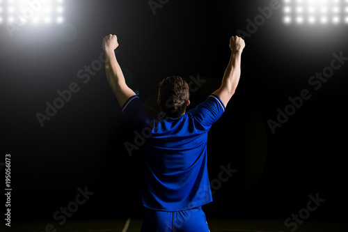 Footballer wearing blue uniform celebrate a goal