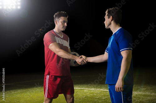 Sportsmen handshake after the soccer game on field