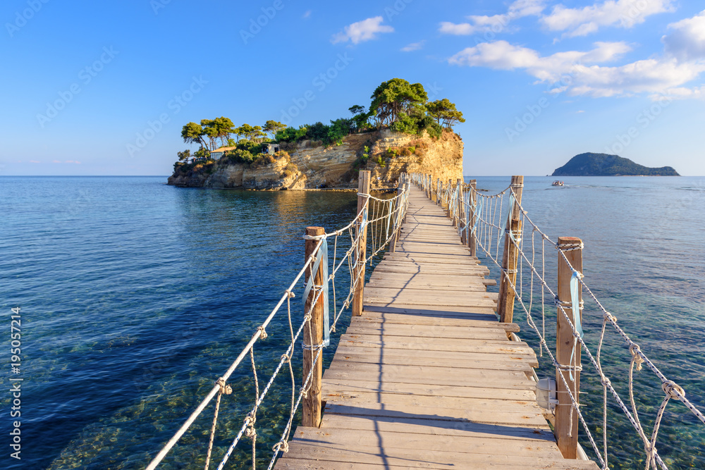 Wooden bridge from Agios Sostis leading to small rocky island. Bay of Laganas, Zakynthos island, Greece.