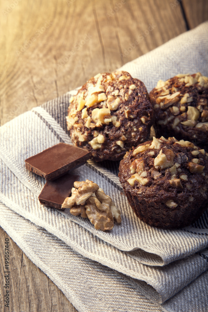 Fototapeta premium Homemade delicious chocolate Muffins with Walnut on wood backround