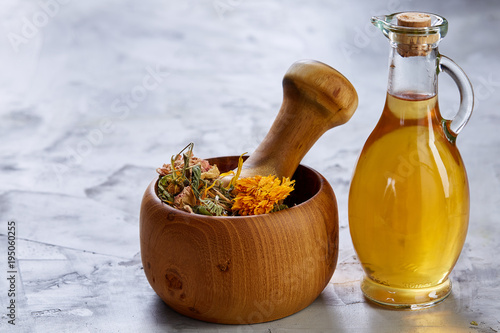 Spa still life with flowers in bowl and oil jars on light textured background, top view, close-up, selective focus photo