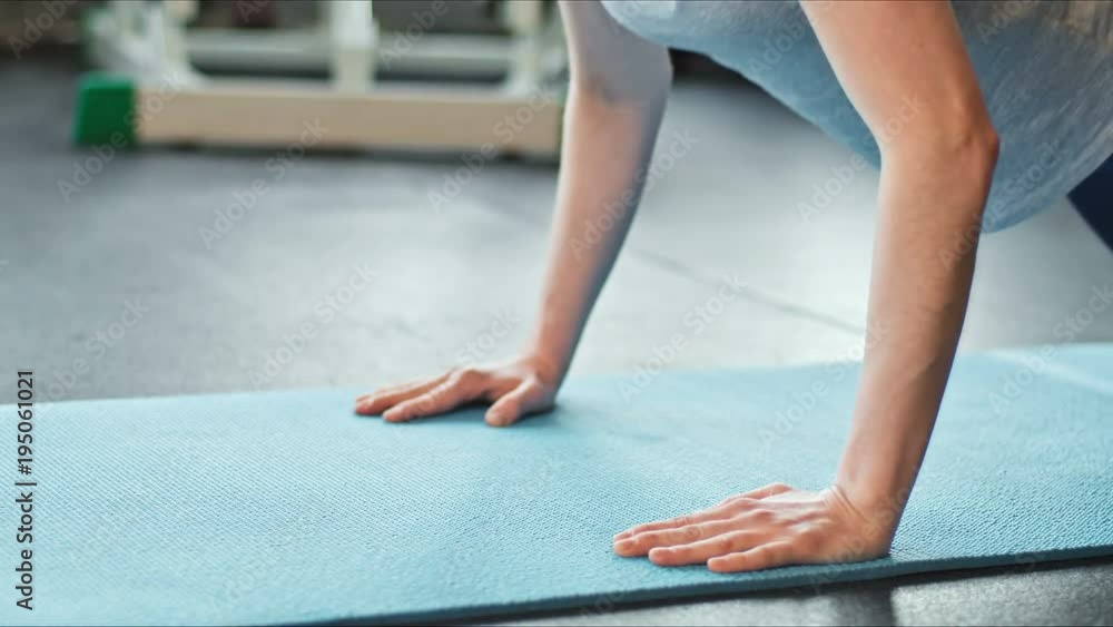 Young woman doing push-ups on exercise mat at gym. Female exercising on fitness mat at gym Young woman doing push-ups on exercise mat at gym. Female exercising on fitness mat at gym