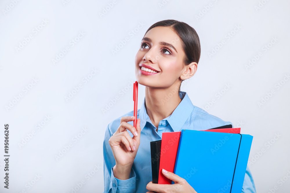 Businesswoman standing with folders on gray background Businesswoman standing with folders on gray background