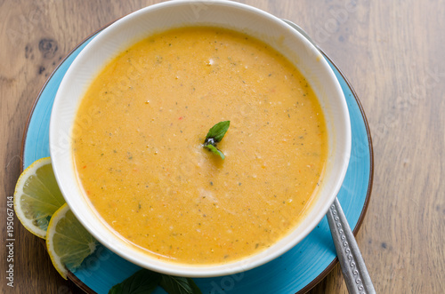 lentil soup in white plate on table. Traditional soup made with potato, oil, onion, tomato paste, spices. Top view.