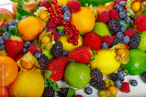 Fototapeta Naklejka Na Ścianę i Meble -  тропические фрукты и ягоды лежат на фоне белых досок
