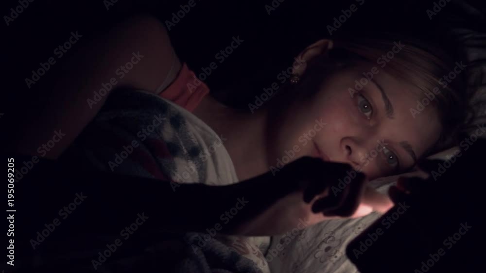 Young woman using smartphone in bed at night Young woman using smartphone in bed at night