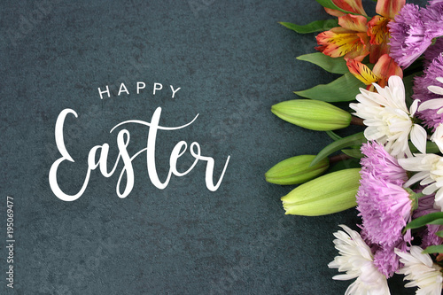 Spring season still life with Happy Easter holiday script text over dark black background texture with beautiful colorful white, pink, orange, purple and green flower blossoms bouquet