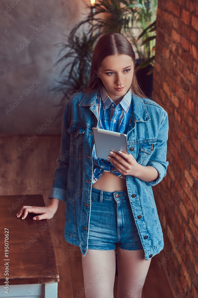 Optimistisch Ter ere van Weg huis A young slim sexy girl in a jeans jacket and flannel shirt leani Stock  Photo | Adobe Stock