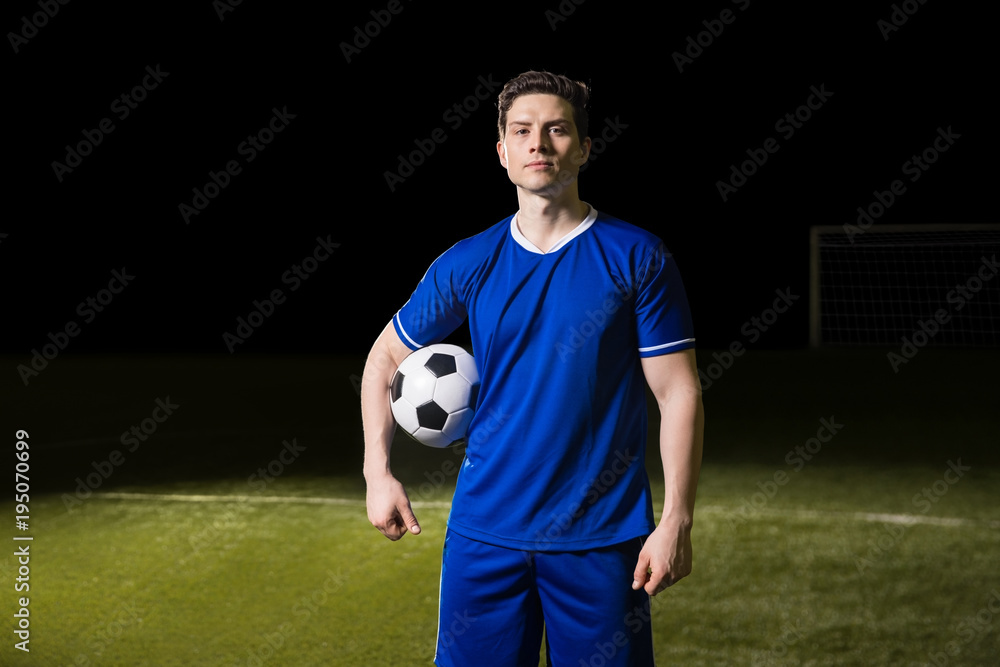 Soccer player in blue jersey on football pitch Soccer player in blue jersey on football pitch