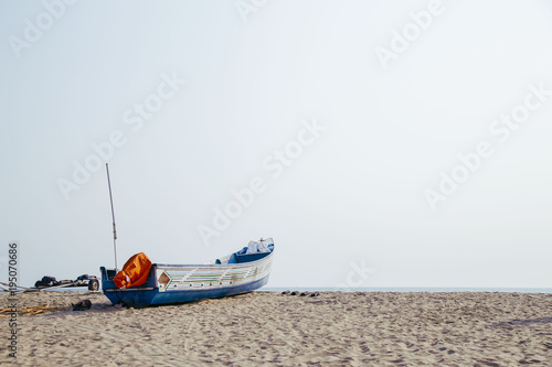 fishing boat on the seashore at summer day photo