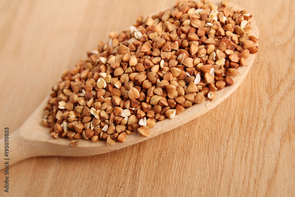 Close-up of buckwheat grains lie in a wooden spoon Close-up of buckwheat grains lie in a wooden spoon