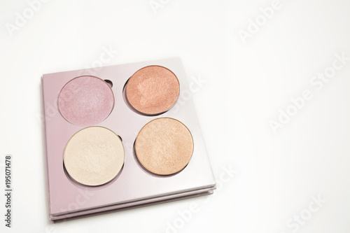 Set of holographic makeup highlighters on a white background