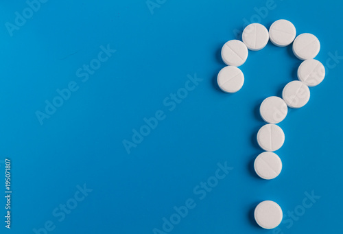 Question mark from white tablets on a blue background