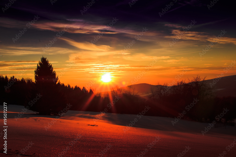 beautiful view over a snowy landscape with a bright sunset