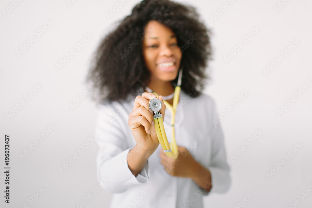 An African American female medical doctor with a stethoscope in hospital on white background An African American female medical doctor with a stethoscope in hospital on white background