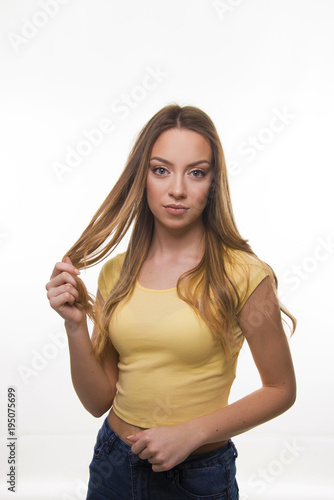 Beautiful young girl unhappy with her long dry and damaged hair cutting dead hear concept 