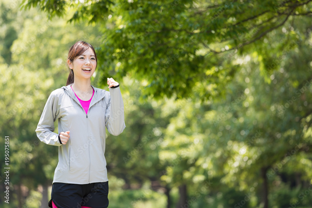 公園でジョギングするスポーティーな女性