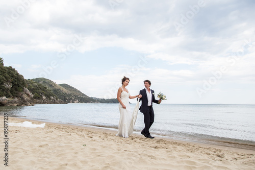 newlyweds walking along the beach