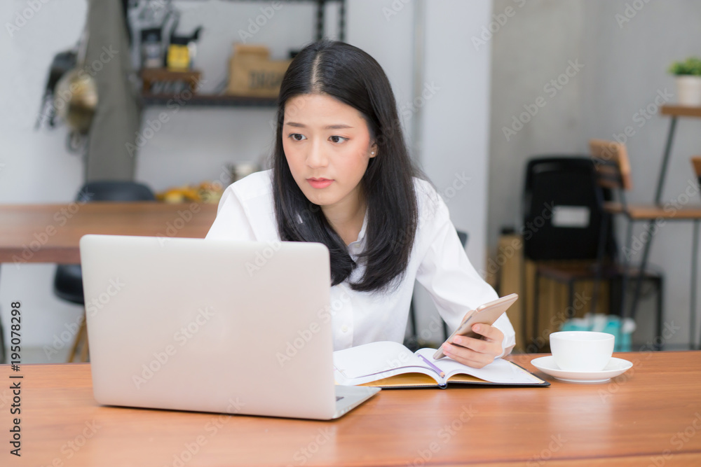 Beautiful asian young businesswoman excited and glad of success with laptop, girl taking mobile phone and working coffee shop on cement background, career freelance business concept. Beautiful asian young businesswoman excited and glad of success with laptop, girl taking mobile phone and working coffee shop on cement background, career freelance business concept.