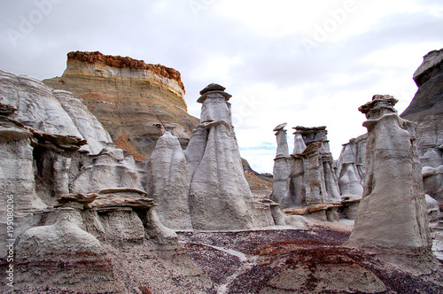 eroded rock formations in desert badlands with grey clouds in the Bisti De Na Zin wilderness in Northern New Mexico