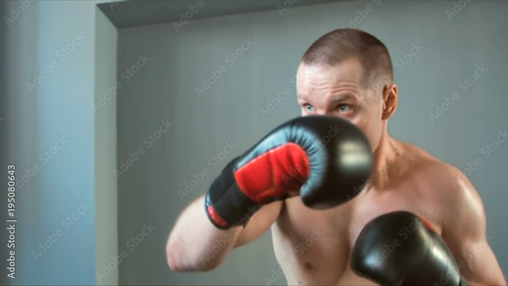 Young caucasian muscular sportsman boxing in gym Young caucasian muscular sportsman boxing in gym