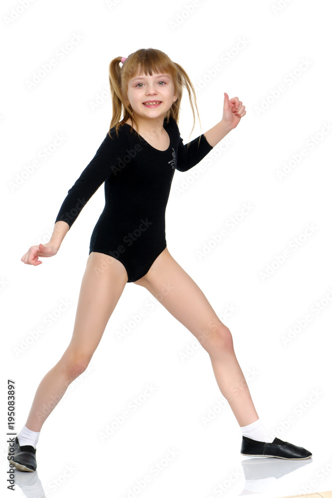 A little girl does gymnastic exercises.