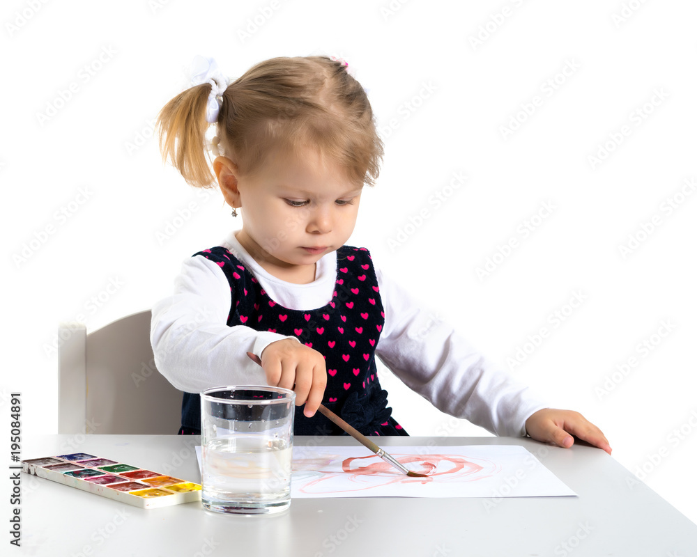 A little girl is drawing at the table. A little girl is drawing at the table.