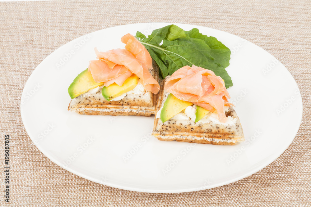 Healthy  breakfast  waffles with avocado and salmon